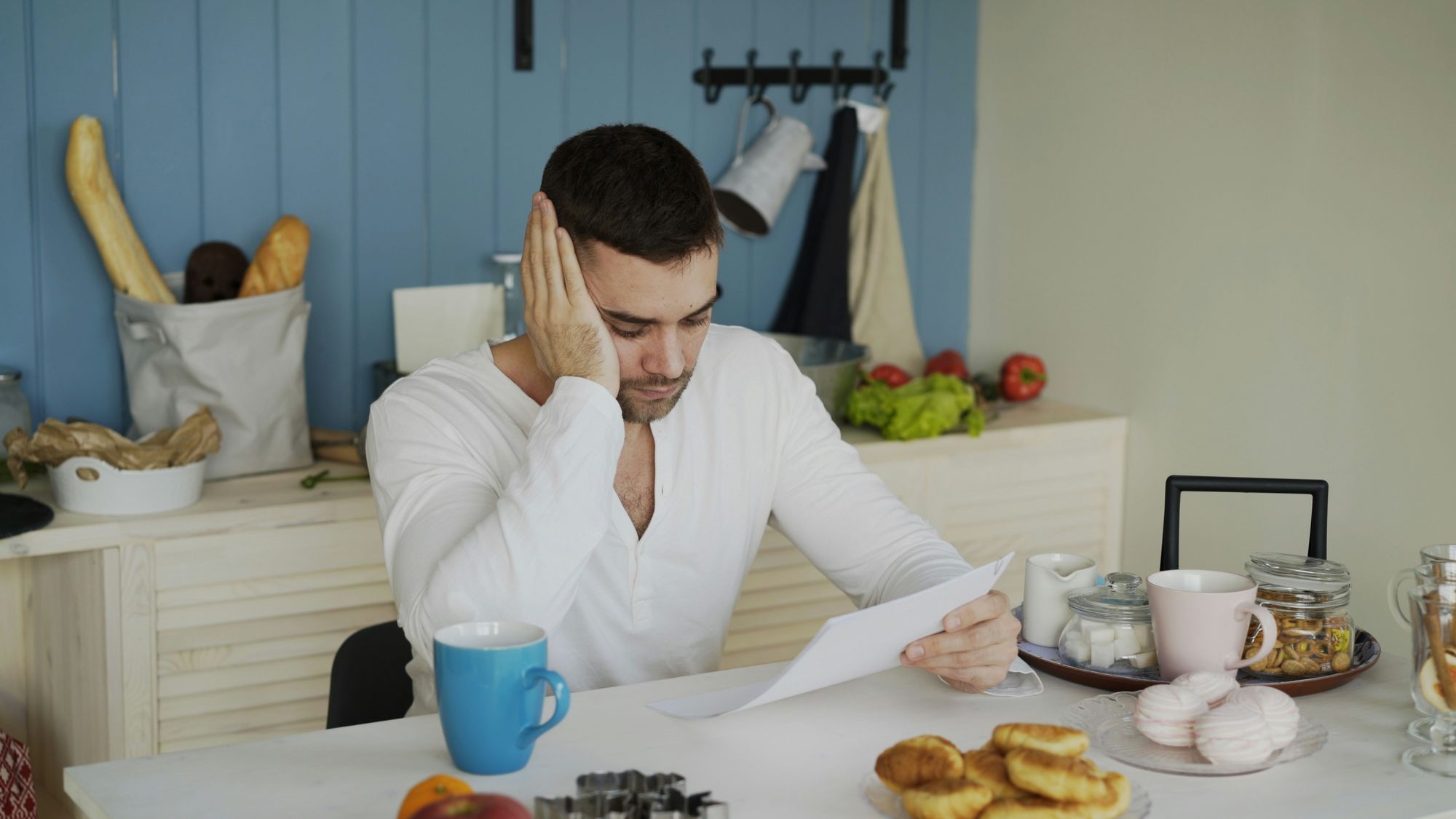 Man reading a letter at his kitchen table