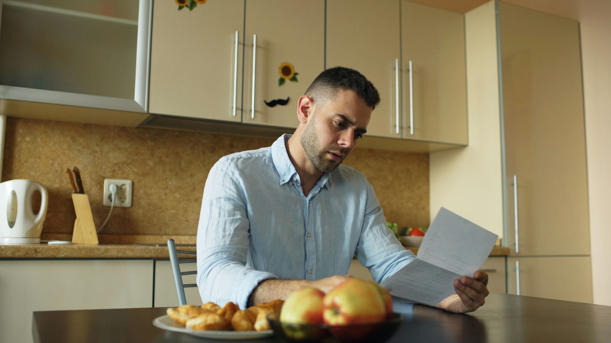 Man reading a document at a kitchen table